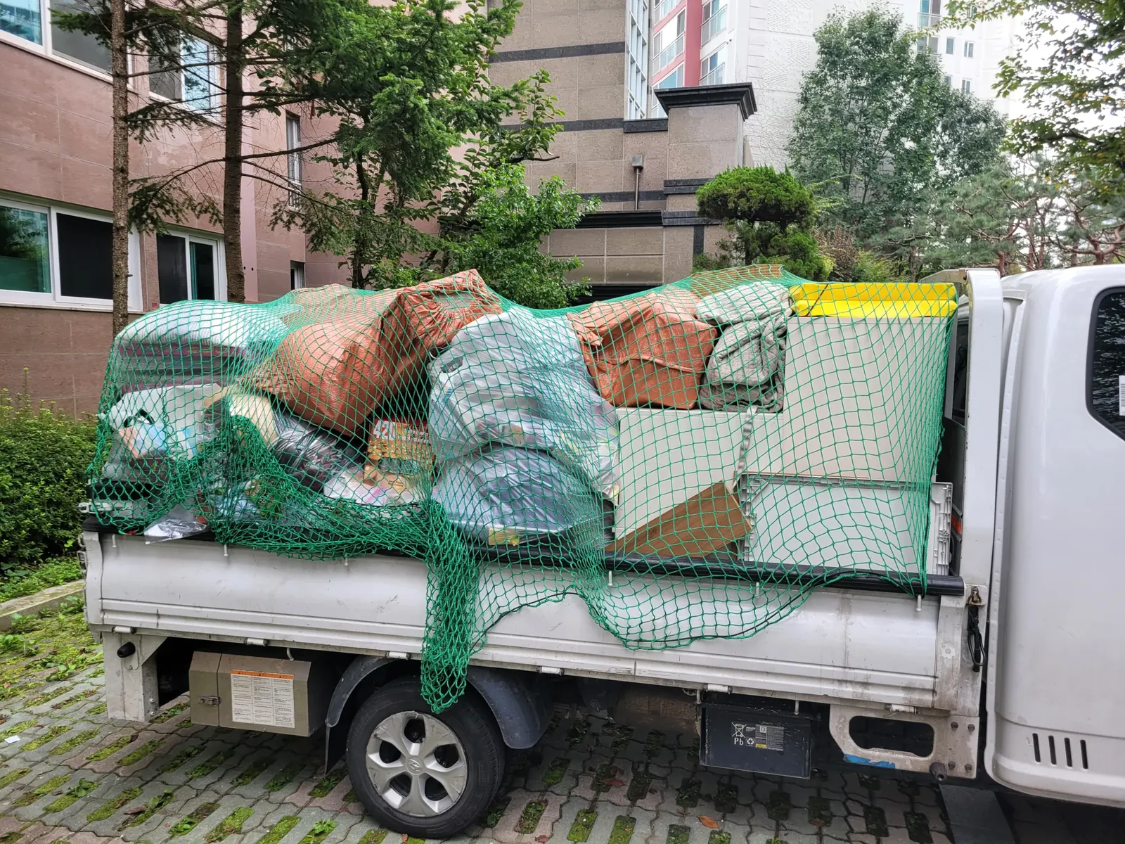수거한 폐기물과 가구를 트럭에 싣고 운송하는 모습