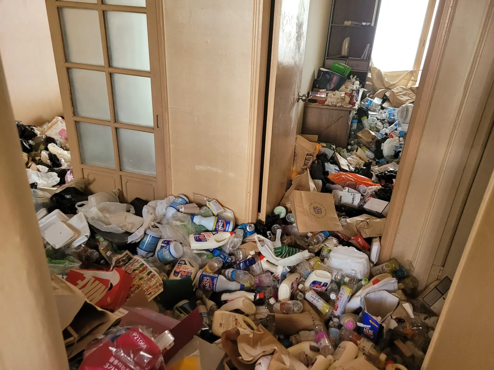 경기 쓰레기집청소 관련 현장: 쓰레기와 물품이 바닥에 쌓인 집 내부 정리 전 모습