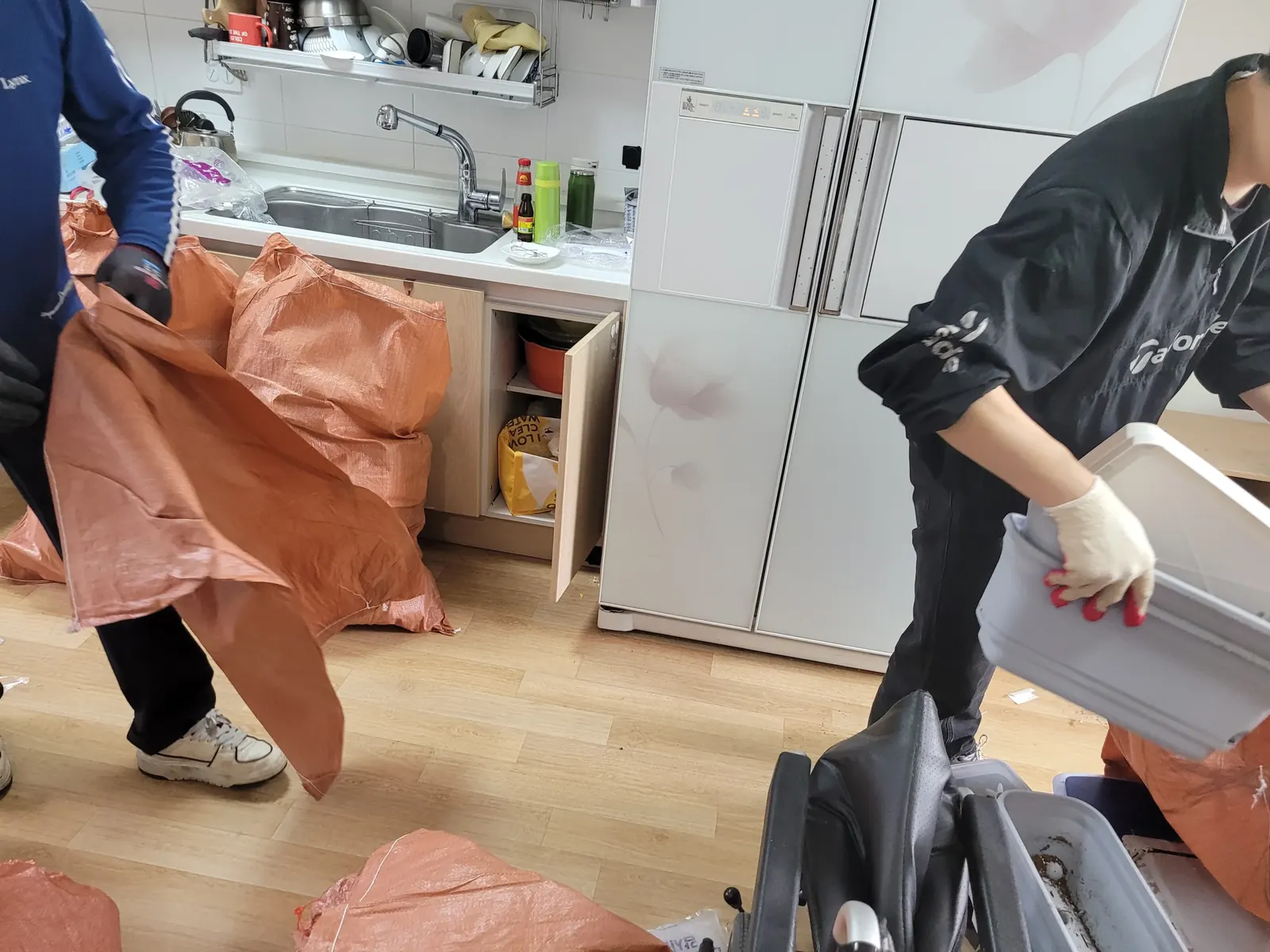 쓰레기집정리 관련 현장: 작업자가 포대에 물품을 담아 정리하는 모습