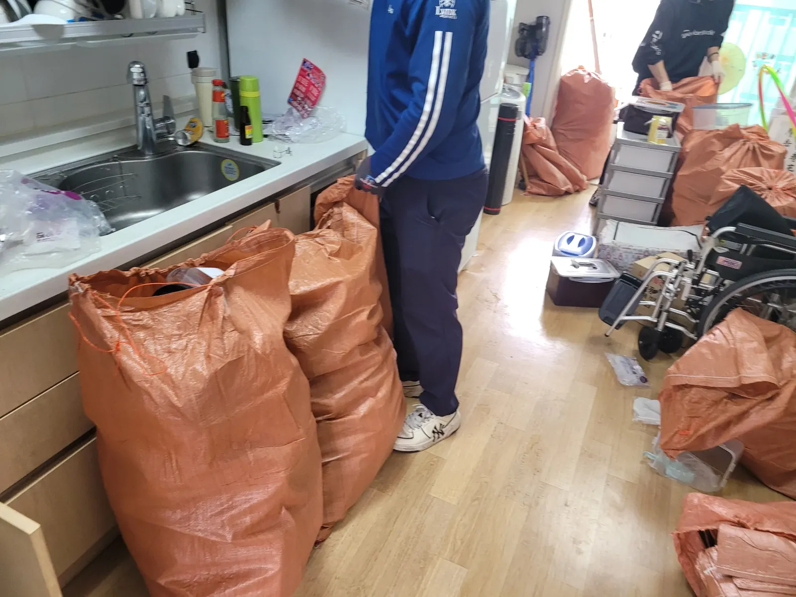 경기 원룸청소 관련 현장: 작업자가 포대로 물품을 담아 반출을 준비하는 모습