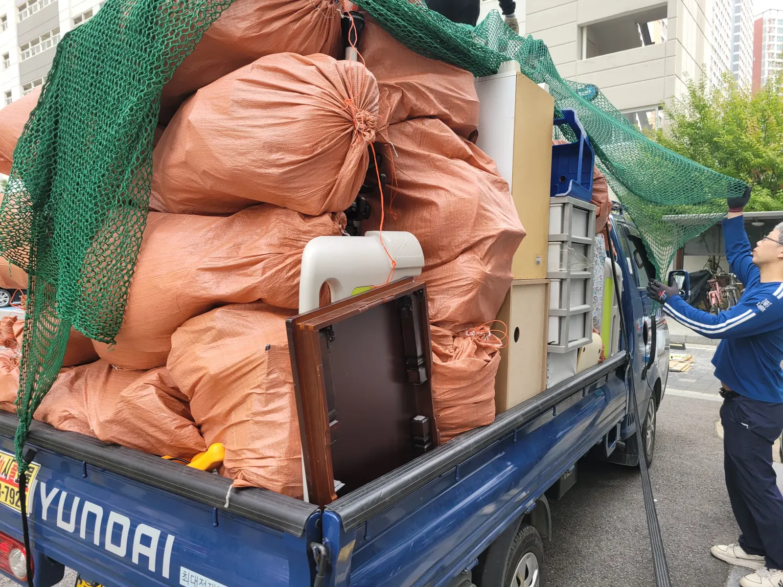 경기 쓰레기집청소 관련 현장: 폐기물과 가구를 트럭에 싣고 고정한 모습