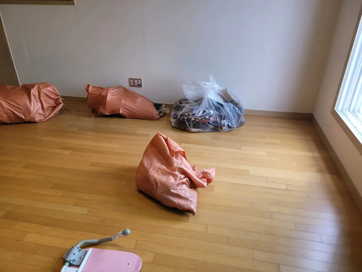 이사 후 잔여 쓰레기 봉투가 남아 있는 빈 방 모습